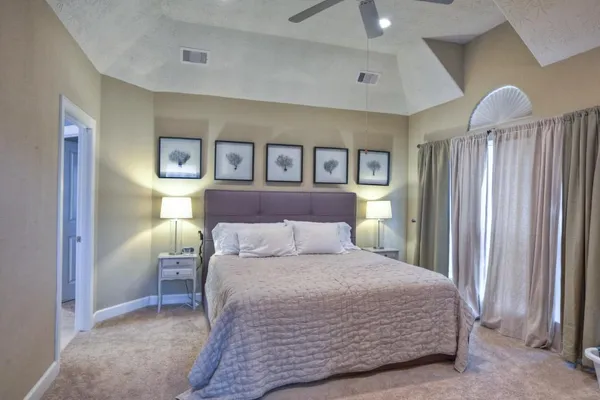 a bedroom with a large bed and a chandelier