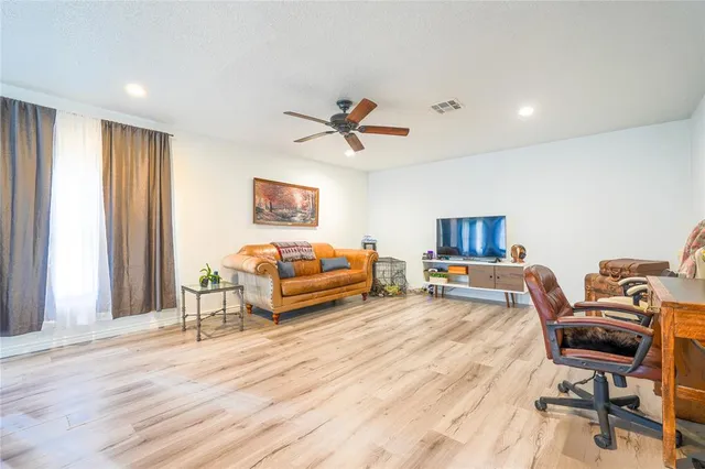 a living room with furniture and a wooden floor