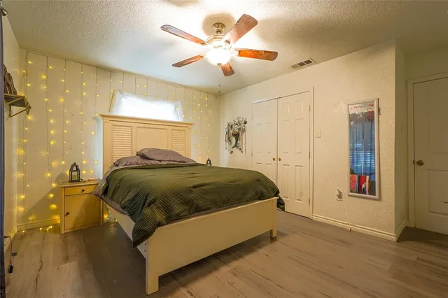 a spacious bedroom with a bed and a chandelier