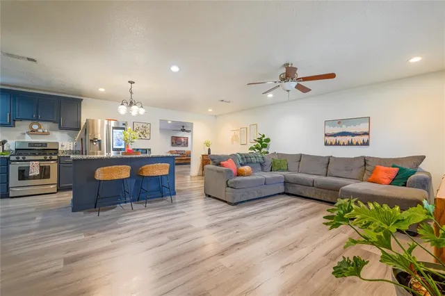 a living room with furniture kitchen and a wooden floor