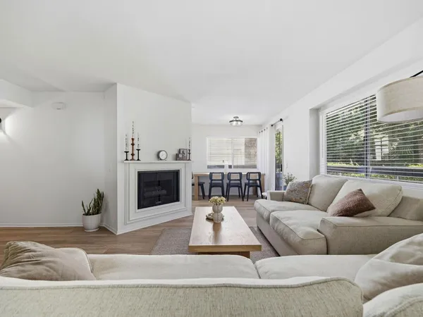a living room with furniture a fireplace and a large window