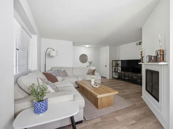 a living room with furniture a flat screen tv and a fireplace