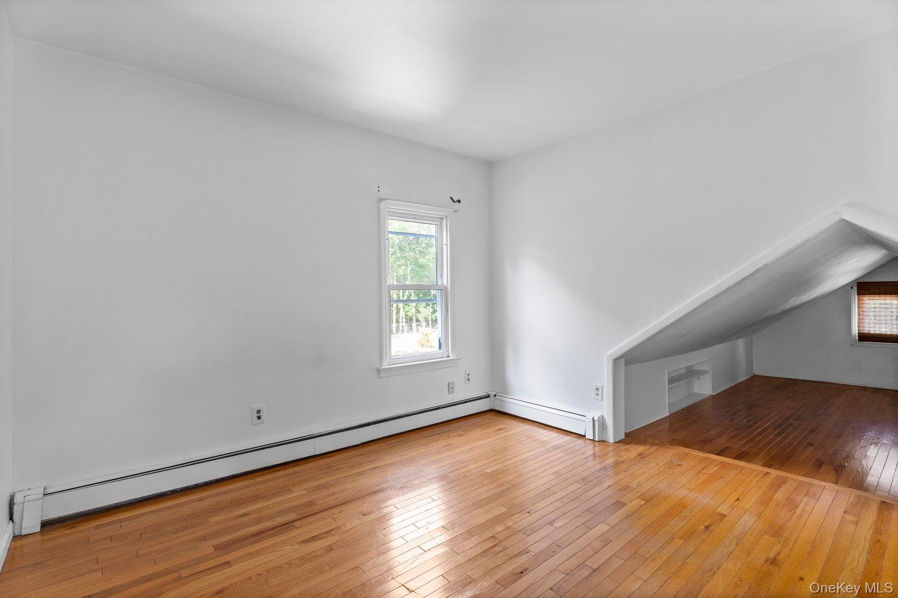 39-41 Foster Road Quogue, NY 11959 - Photo 9 of 13 an empty room with wooden floor and windows