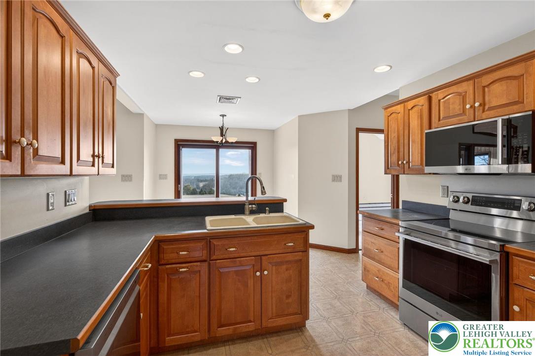 3338 Spring Valley Road Slatington, PA 18080 - Photo 32 of 53 a kitchen with stainless steel appliances granite countertop a stove a sink and a microwave