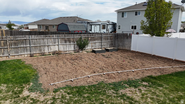 1437 925 South Vernal, UT 84078 - Photo 41 of 47 Expansive backyard space with a section of manicured lawn, a large tilled area, and two raised garden beds