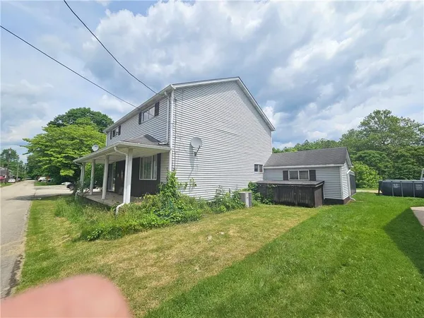 a view of a house with a yard and sitting area