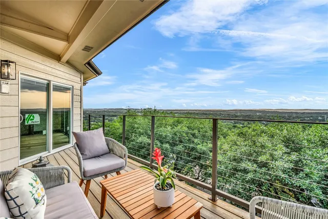 a balcony with wooden floor and outdoor seating