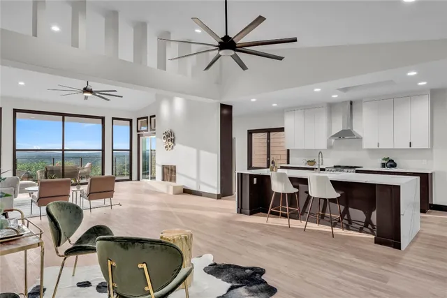 a living room with stainless steel appliances kitchen island furniture and a large window