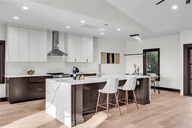 a kitchen with stainless steel appliances granite countertop a table chairs sink and cabinets