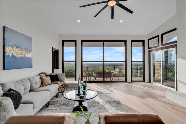 a living room with furniture and floor to ceiling windows