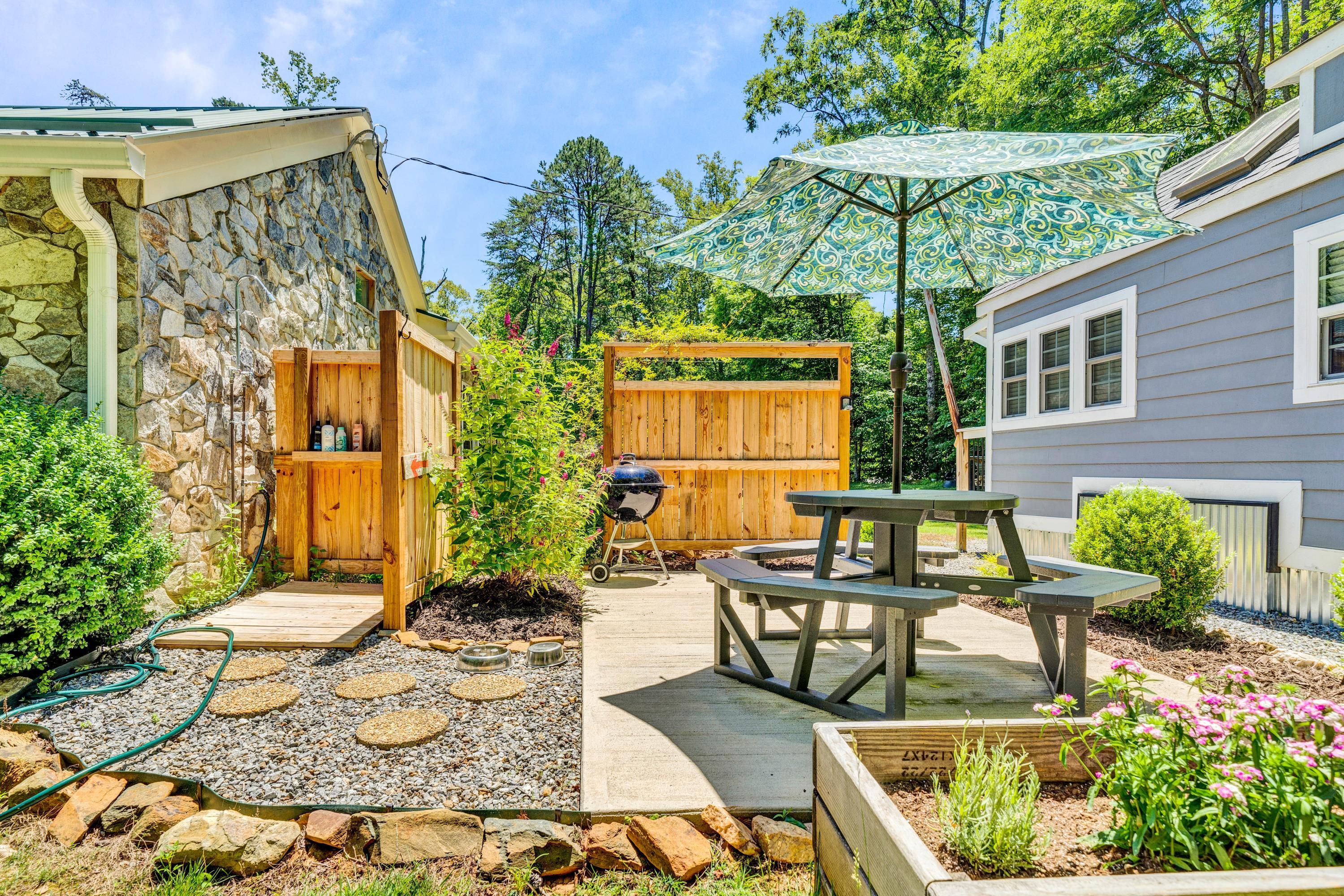 670 Twin Ridge Marina Road Henry, VA 24102 - Photo 19 of 87 a view of a patio with couches table and chairs under an umbrella