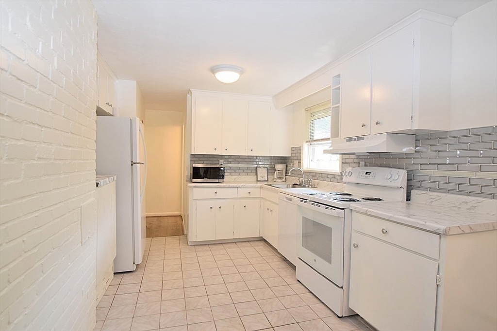22 Devine Road Randolph, MA 02368 - Photo 9 of 27 a kitchen with white cabinets and white appliances