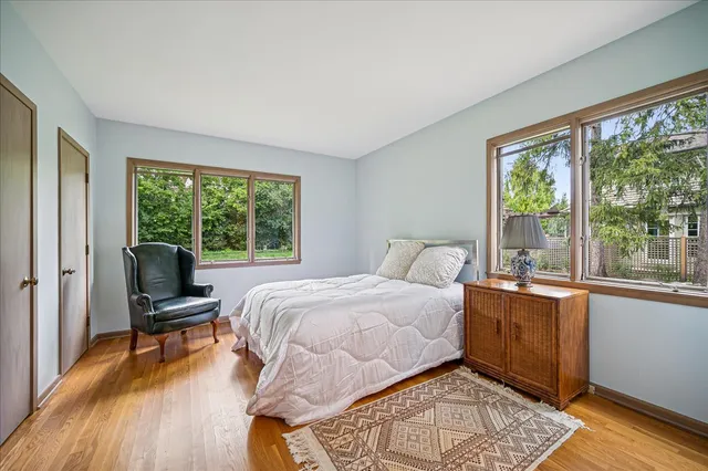 a bedroom with a bed and large windows