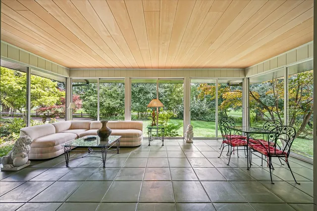 a living room with patio furniture and a floor to ceiling window