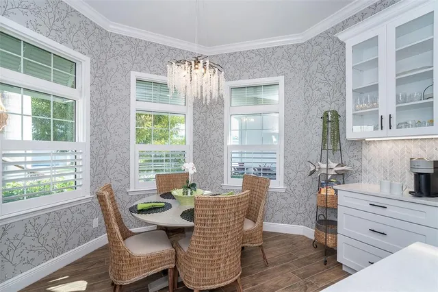 a dining room with furniture a chandelier and wooden floor