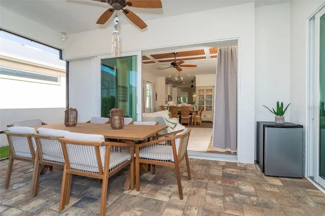 a dining room with wooden floor a chandelier a glass table and chairs