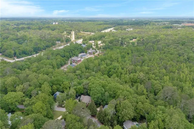 an aerial view of residential houses with outdoor space and trees