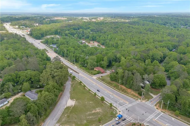 an aerial view of residential houses with outdoor space and trees