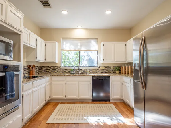 a kitchen with a refrigerator and white cabinets