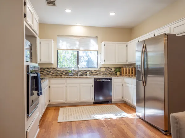 a kitchen with stainless steel appliances granite countertop a refrigerator and a stove top oven