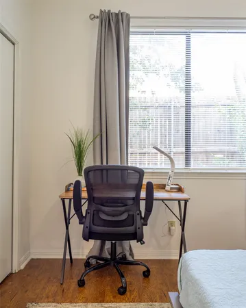 a view of a workspace with furniture and a window