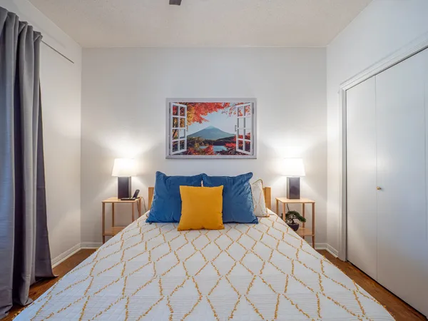 a bedroom with a bed and a painting on the wall