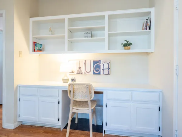 a white kitchen with a table and chair
