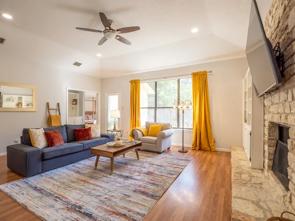 a living room with fireplace furniture and a rug