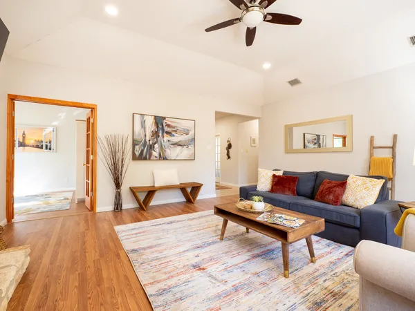 a living room with furniture and a wooden floor