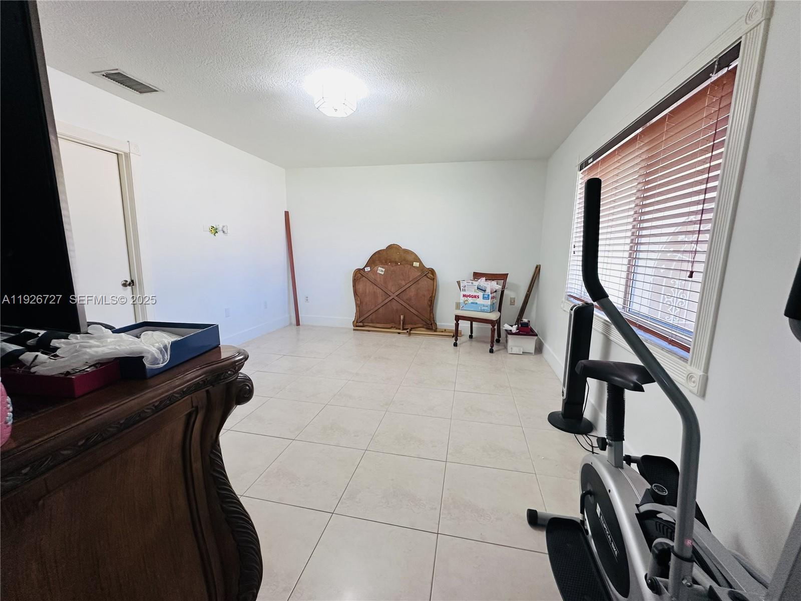 165 Southwest 130th Avenue Miami, FL 33182 - Photo 7 of 20 a bedroom with a bed and cabinets