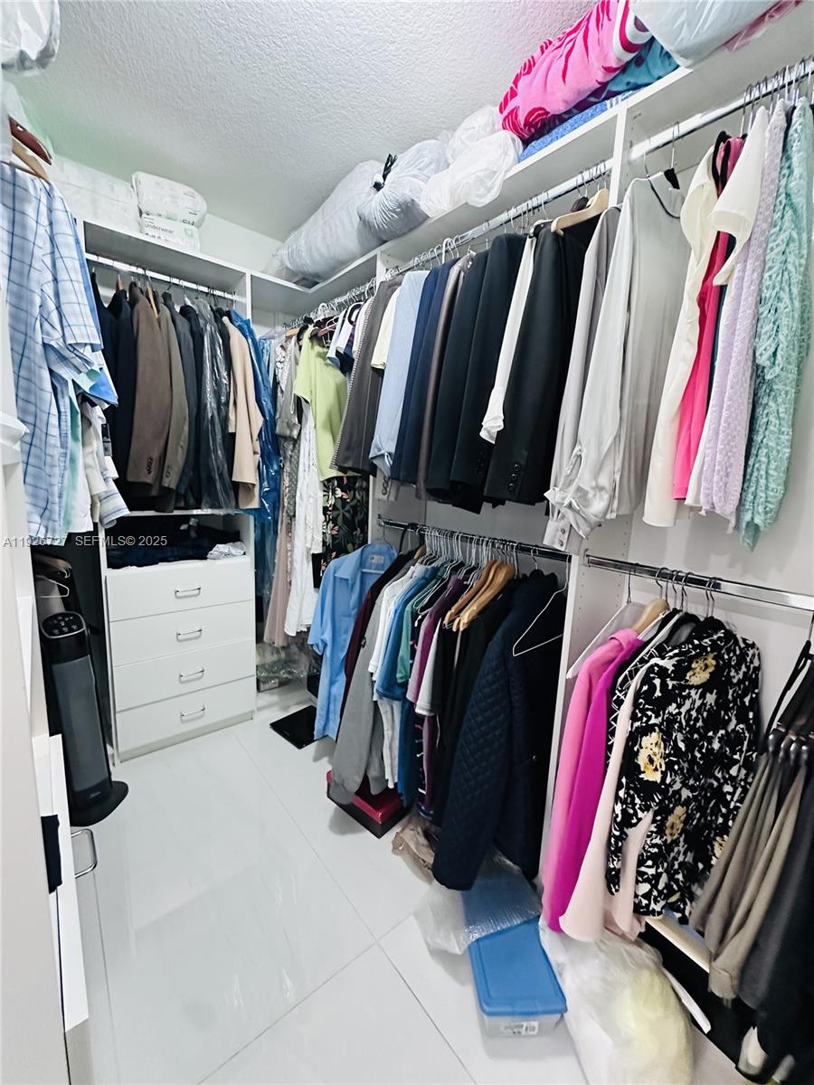 165 Southwest 130th Avenue Miami, FL 33182 - Photo 10 of 20 a view of walk in closet with clothes and shoes