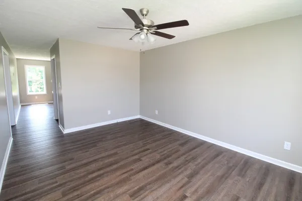a view of an empty room with wooden floor