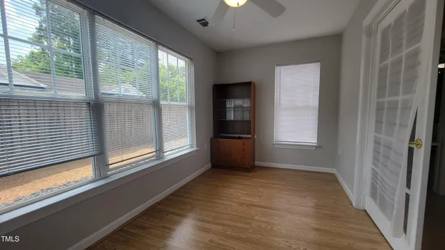 a view of an empty room with a window and wooden floor