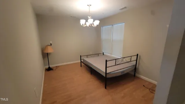 a view of a room with a hanging light and hardwood