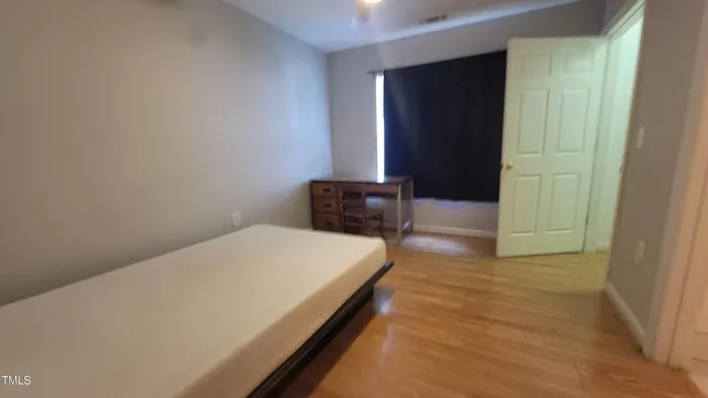 a bedroom with a bed and wooden floor