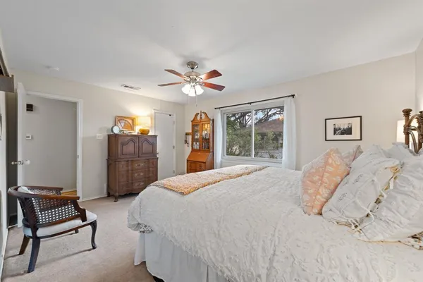 a bedroom with a large bed chandelier and a window