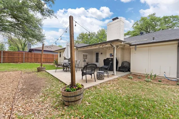 a backyard of a house with table and chairs