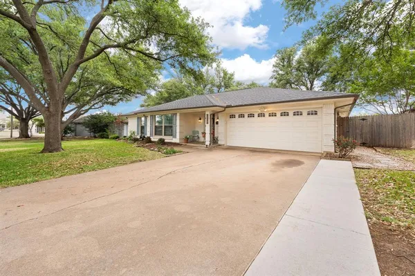 a front view of a house with a yard and trees