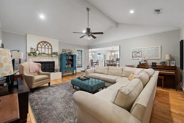 a living room with furniture a fireplace and a chandelier