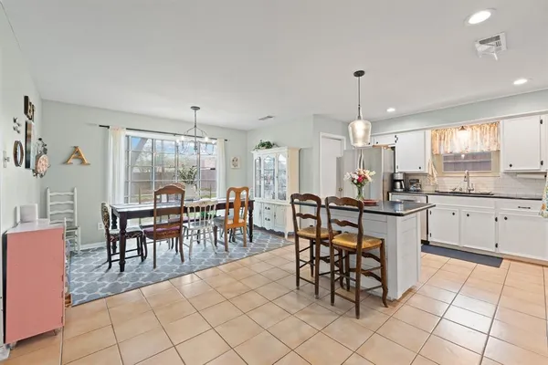 a open kitchen with stainless steel appliances granite countertop a table and chairs in it