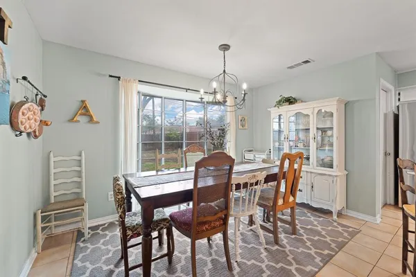 a dining room with furniture a chandelier and wooden floor