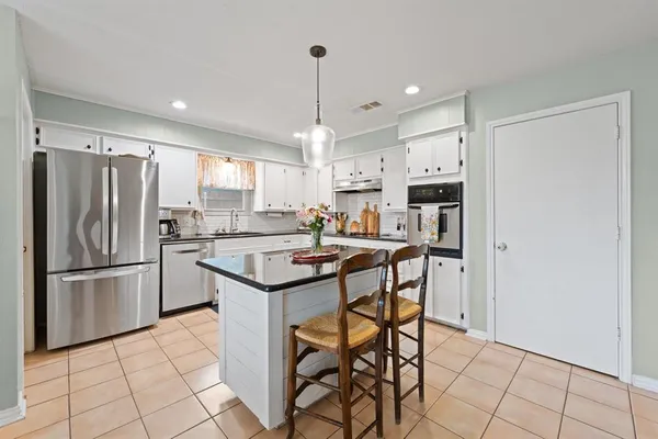 a kitchen with stainless steel appliances a refrigerator a stove a sink and a refrigerator