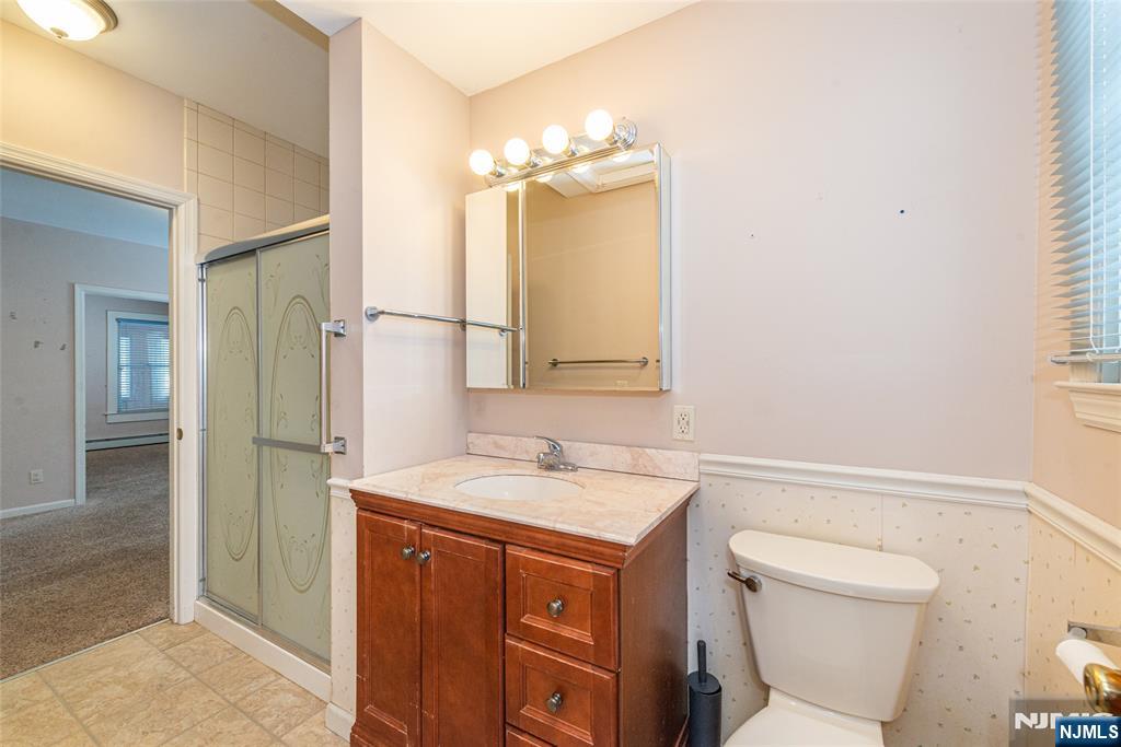 573 Wyckoff Avenue Mahwah, NJ 07430 - Photo 15 of 30 a bathroom with a sink a toilet and a mirror