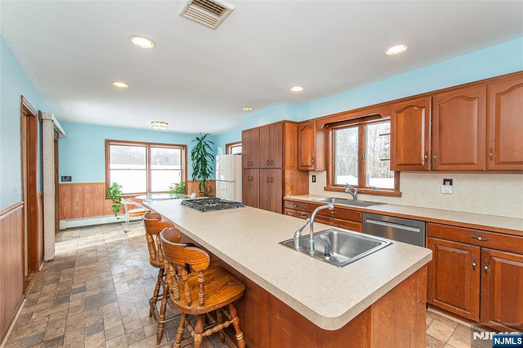 573 Wyckoff Avenue Mahwah, NJ 07430 - Photo 6 of 30 a kitchen that has a sink a table and chairs in it