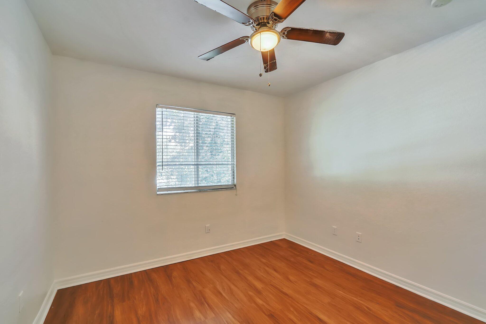 1969 Alamanda Way, Unit 1969 Riviera Beach, FL 33404 - Photo 7 of 26 an empty room with wooden floor chandelier fan and windows