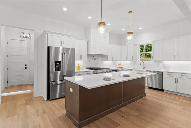 a kitchen with a sink a stove cabinets and a window