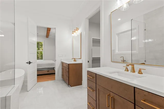 a bedroom with a bed couches and two windows