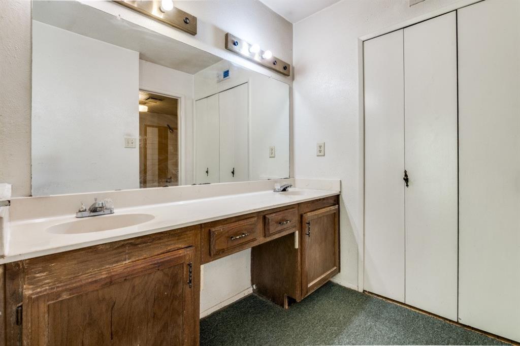 7049 Sorcey Road Dallas, TX 75249 - Photo 11 of 12 a spacious bathroom with a double vanity sink and a mirror