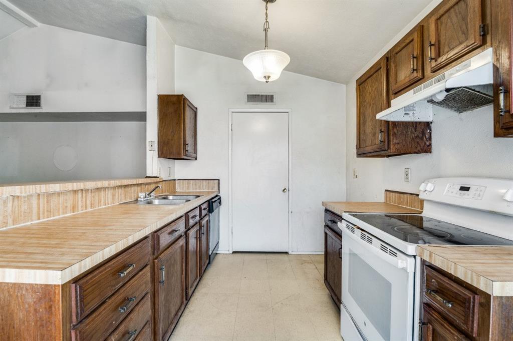 7049 Sorcey Road Dallas, TX 75249 - Photo 6 of 12 a kitchen with a sink stove and microwave