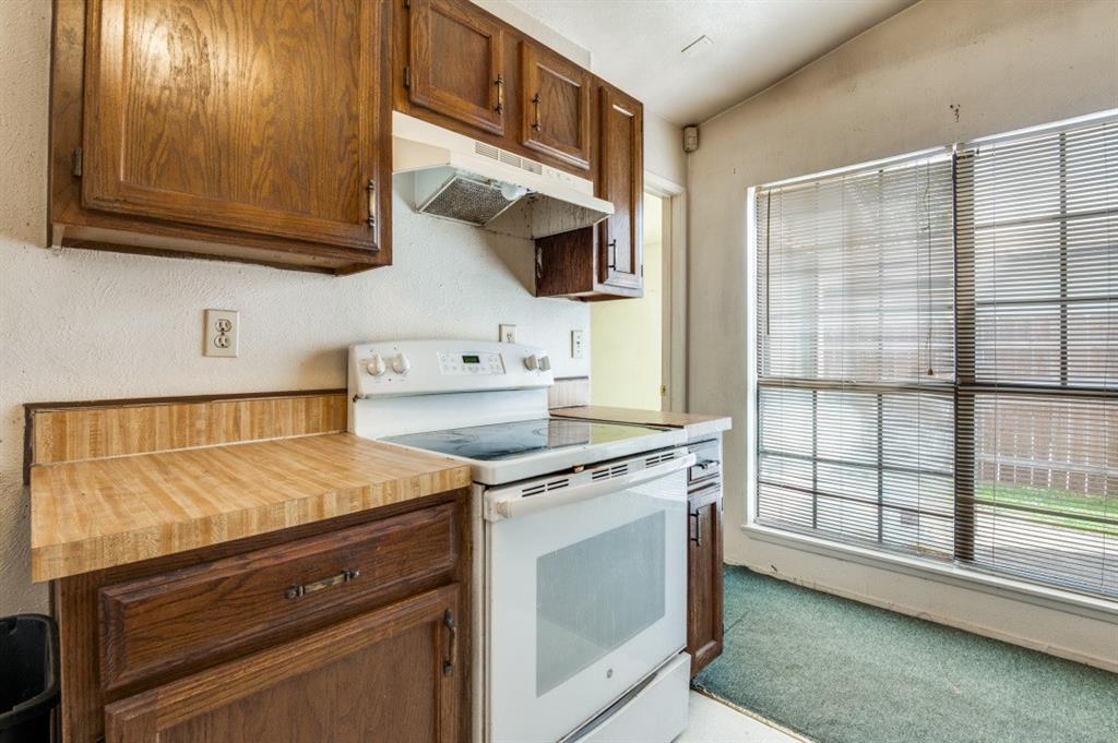 7049 Sorcey Road Dallas, TX 75249 - Photo 7 of 12 a kitchen with stainless steel appliances granite countertop a stove a sink and a microwave